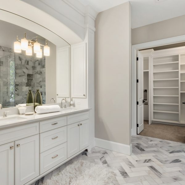 bathroom with beautiful circular mirror and hardwood vanity